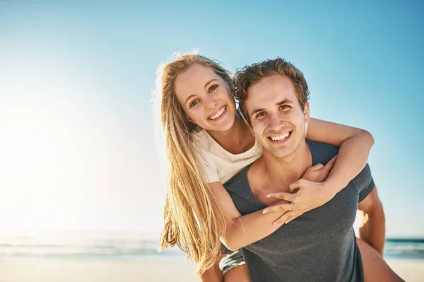 愛は夏をさらに素晴らしいものにします 幸せな若いカップルがビーチでピギーバックに乗って — ストック写真