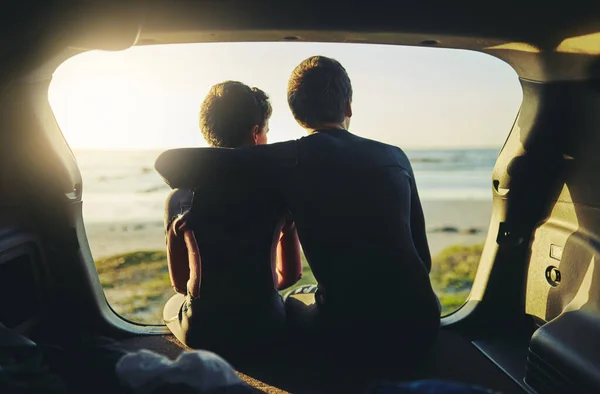 彼らは海の愛を共有しています ビーチで車の後ろに座っている2人の正体不明の兄弟のレビューショット — ストック写真
