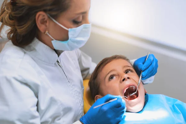 没有痛苦 没有压力 一个小男孩躺在牙医的椅子上 同时接受牙医的检查 — 图库照片