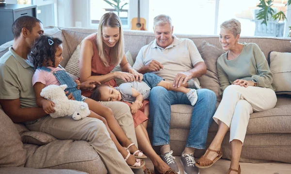 Big family, happiness and love on house sofa with children, parents and grandparents together for bonding, quality time and relax. Happy kids, women and men in interracial family home in Europe.