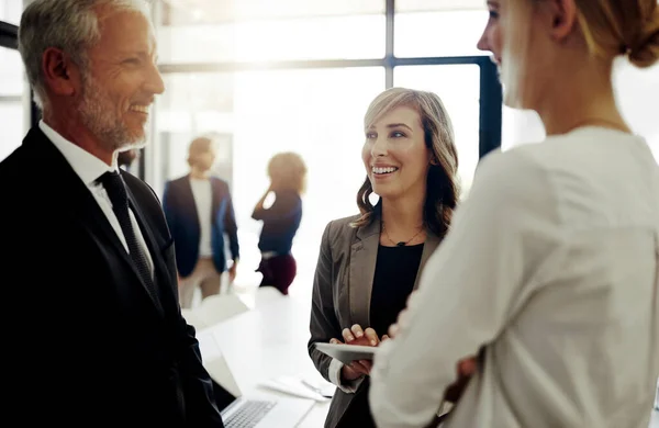 stock image Progress is always positive. three businesspeople talking while standing in the office