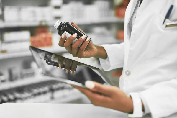 stock image We need more of this kind. a unrecognisable female pharmacist holding a digital tablet in one hand and medication in the other inside of a pharmacy