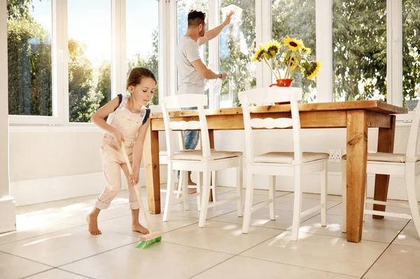 Keeping their home extra clean. a father and his little daughter doing chores together at home