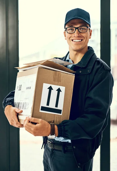 Delivered on time and with care. Portrait of a courier making a delivery