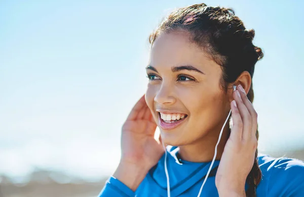 stock image Time to get the heart pumping to these great tunes. a sporty young woman listening to music while exercising outdoors