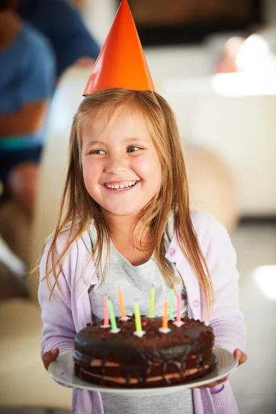 誕生日ケーキなしでは誕生日ではありません 背景に家族とお誕生日ケーキを持っている幸せな女の子がいて — ストック写真