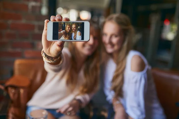 stock image Theyre always taking selfies. two attractive young girlfriends taking selfies while sitting in a cafe