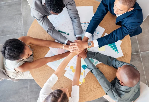 Hands, teamwork and motivation with a business team sitting at a table in a boardroom from above. Collaboration, meeting and unity with an employee group working on finance or accounting documents.