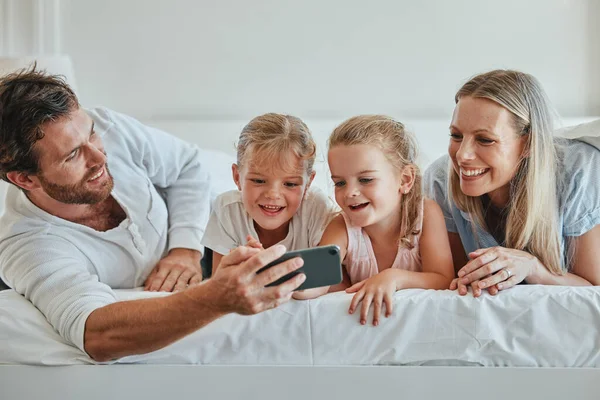 Family, bedroom and selfie for bonding and love while at home with a smartphone. Bed, phone and photo of happy parents relaxing in together for affection, loving and caring relationship in home.