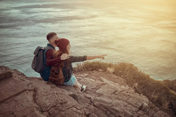 你可以从这里看到海洋的尽头 一对深情的年轻夫妇从山顶上俯瞰风景的全景镜头 — 图库照片
