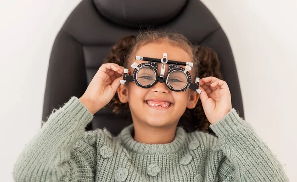 Vision, eye exam and girl with trial lens for prescription spectacles at optometry shop. Eyewear, eyesight test and happy child trying new optical lenses for optic health, wellness and care in clinic.