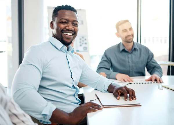 Meeting, corporate and portrait of African businessman sitting in the office boardroom with his team. Happy, smile and professional black man planning a company strategy or project in conference room.