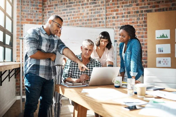 stock image Teamwork simplifies the task. a group of colleagues using a laptop together in a modern office