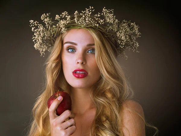 魅惑的だな スタジオショットのA豪華な若い女性食べるA赤リンゴに暗い背景 — ストック写真