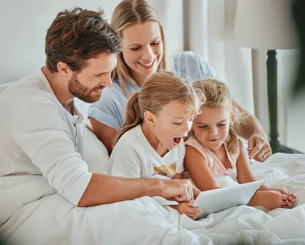 Parents, kids and tablet learning in bedroom, games and watching cartoons on internet, online and relax at home. Happy family of mom, dad and excited children, digital fun and educational app on tech.