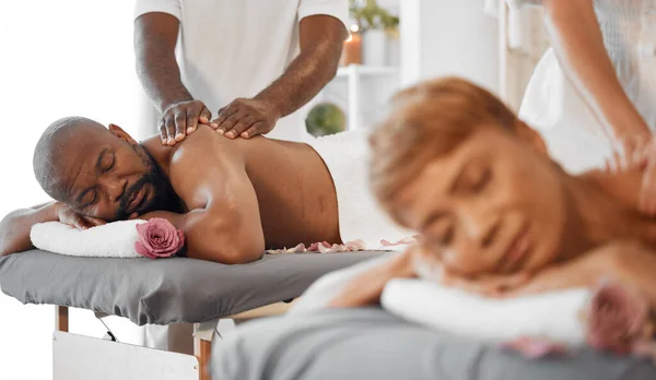 Black couple, massage in spa with massage therapist and wellness, romantic holiday for stress relief and body care. Beauty, calm and health with luxury service, aromatherapy and body wellbeing