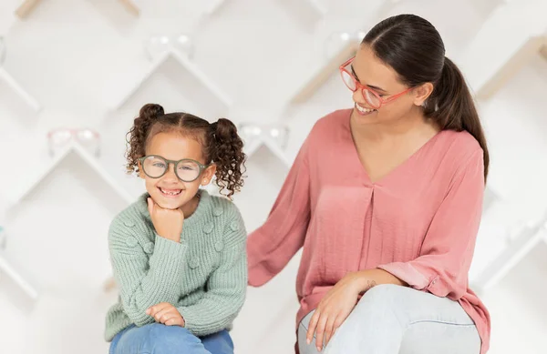 Shopping, vision and glasses with mother and girl buying eyewear together in retail store. Woman, daughter and consumer optics while buy eyeglasses in optometry shop for eye health and eye care.