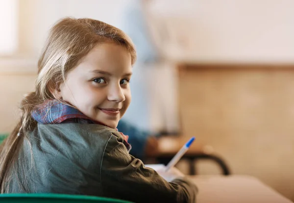 学校はクールで 彼女はそれを愛しています 教室に座っている小学生の女の子のレビューの肖像 — ストック写真
