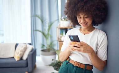 Kadın, komik bir sosyal medya telefonu ve oturma odasında online randevu profili bildirimi ile mutlu. Afro saçlı genç bayan evde rahatla, akıllı telefon bağlantısı ve 5G mobil ağ teknolojisi.