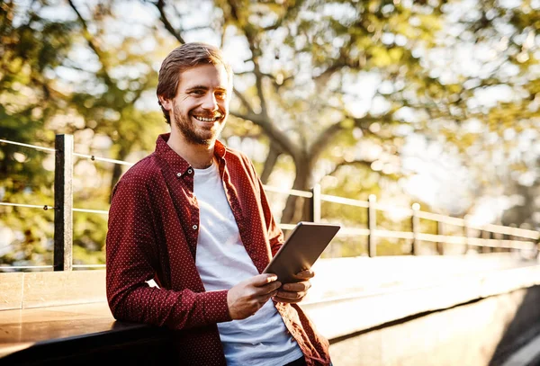 stock image The wife here is great. Cropped portrait of a handsome young man using his digital tablet outside