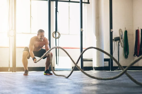 stock image These ropes will transform you. a muscular young man working out with heavy ropes at the gym