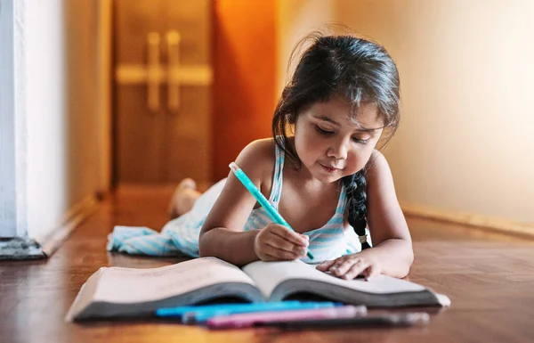 像个好女孩一样做作业白天躺在家里的时候 一个专心致志地在书上写作的小女孩 — 图库照片