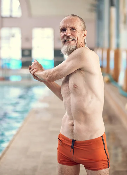 stock image Ive still got the moves. Portrait of a happy senior man exercising by a swimming pool at a gym