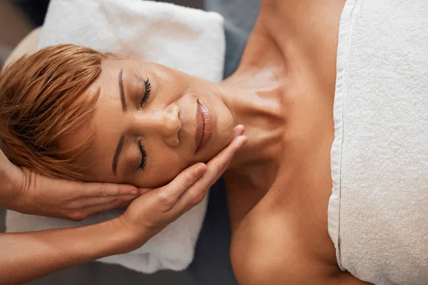 Black woman, beauty head massage and facial skincare treatment to restore health, relax face muscle and reduce aging. Luxury spa, a healthy and organic zen skin therapy wellness treatment with hands.