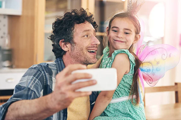 stock image Ah, youve done this selfie thing before. a happy father and daughter taking a selfie together on a mobile phone at home