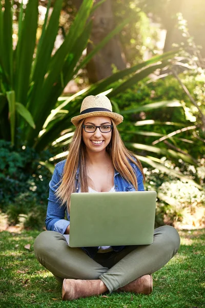 햇볕에 합니다 풀밭에서 노트북을 사용하는 매력적 여자의 — 스톡 사진