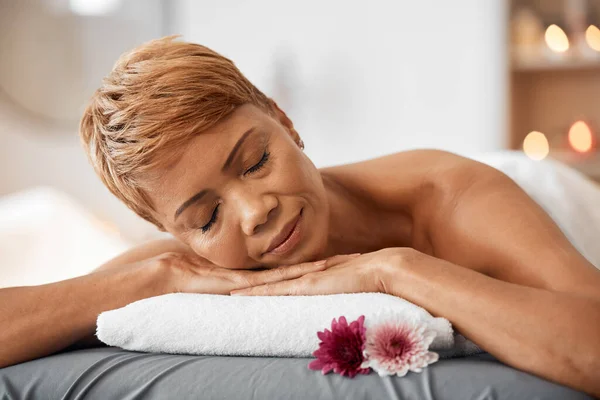 Relax, massage and woman being peaceful, calm and stress free for tension, laying on table and physical therapy treatment. Spa, mature female and enjoy body care for wellness, health and resting