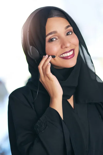 電話の反対側にあるフレンドリーな顔 現代のオフィスで働くフレンドリーな若いイスラム教徒のコールセンターエージェントの肖像 — ストック写真