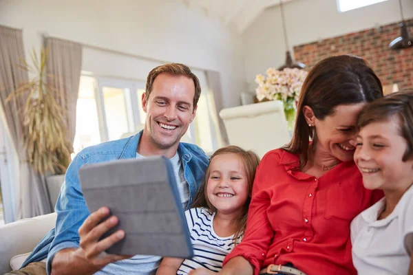 가족을 즐겁게 부모들 소파에서 디지털 태블릿을 사용하여 — 스톡 사진