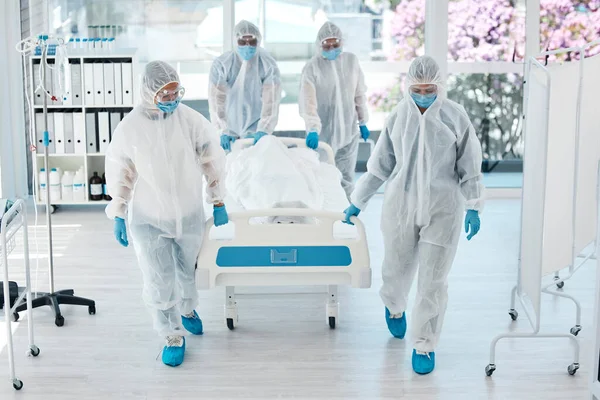 検疫や検査のために病院で患者ストレッチャーとコヴィド パイプや医師 医療従事者は Covid 19が死亡した後にクリニックでベッドを押すハズマットスーツ — ストック写真