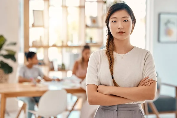 Portrait, leadership and meeting with an asian woman in business standing arms crossed in a boardroom. Confident, leader and planning with a young female employee ready for strategy or training.