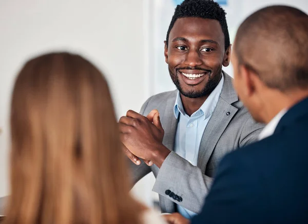 Corporate, smile and black man in a meeting with management for business, planning and strategy. Teamwork, business meeting and African businessman talking to employees about an idea for company.
