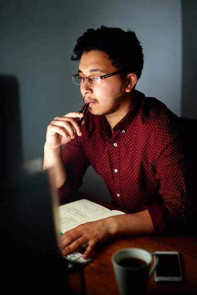 オフィスを出る前に仕上げをいくつか入れてください 夜遅くにコンピューターを使っていた若い男性デザイナーが — ストック写真