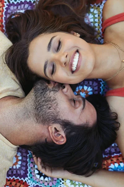 真の愛のキスに勝るものはありません 外の毛布の上でリラックスして幸せな若いカップルの高角度ショット — ストック写真