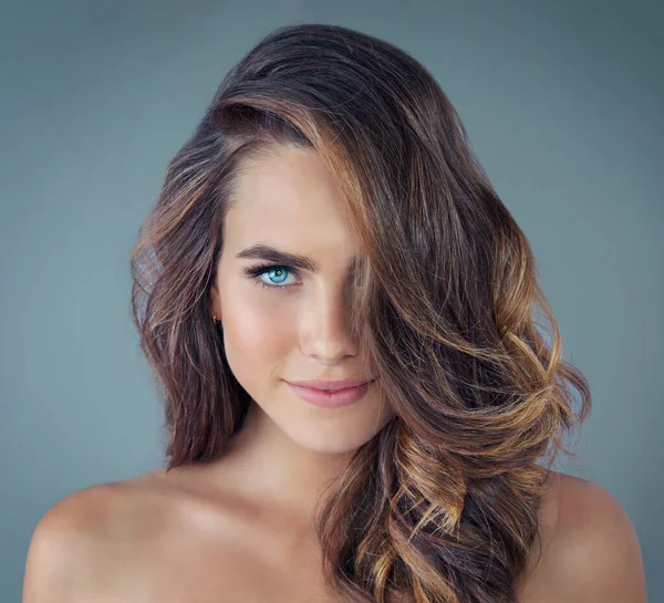 Beautiful blue eyes. Cropped portrait of a beautiful young woman posing against a grey background in the studio