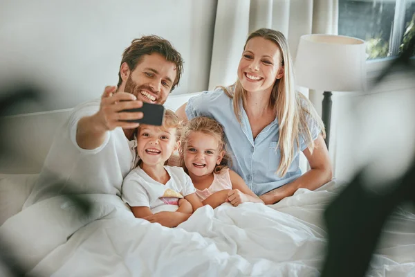 床和快乐的家庭带着微笑 享受着美好的时光 与家人团聚 在家里放松一下 父母带着年幼的孩子 孩子或兄弟姐妹在卧室里 — 图库照片