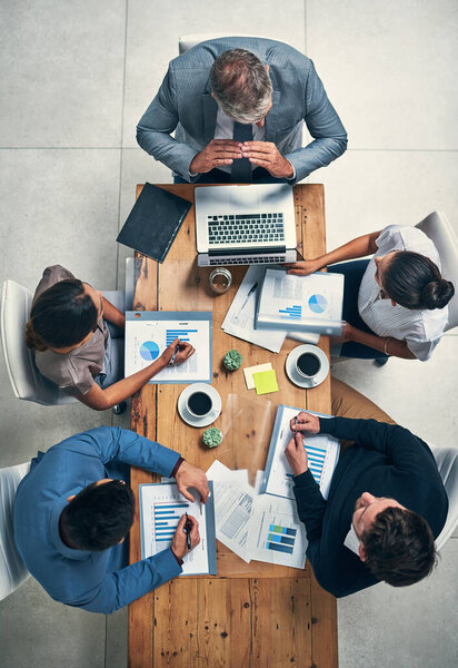 Boosting business together. High angle shot of a group of businesspeople having a meeting in an office