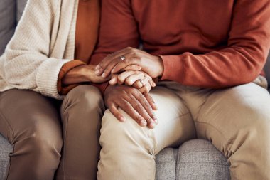 Black couple, holding hands on sofa or comfort support, care and love bonding together in home living room. Black man, black woman sitting couch and embrace with kindness, trust and help with problem. clipart