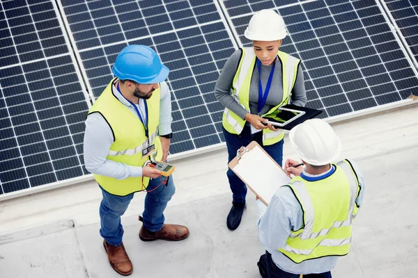 Top view, engineer teamwork and planning of solar panel maintenance, inspection or installation. Solar energy, renewable energy and group of contractors with tablet, tech or checklist in discussion