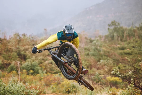 Mountain bike, man and air jump, action and bicycle stunt, challenge and adventure, freedom or dynamic risk in outdoor competition race. Biker athlete, sports adrenaline and energy for extreme sports.