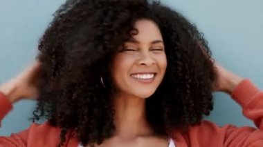 Doğal, kıvırcık ve siyah kadın saç bakım ürünleri kullandıktan sonra cildiyle oynuyor. Çekici Afrikalı Amerikalı kız sağlıklı ve kıvırcık saçlı güzellik kampanyası için.