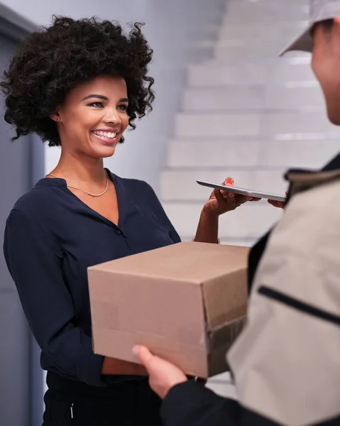 Office supplies direct to your door. a happy businesswoman accepting a package from a courier in the office