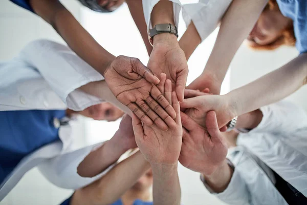 あなたの健康を確保するために最善を尽くします 団結して手を携えている医療従事者のグループの低角度ショット — ストック写真
