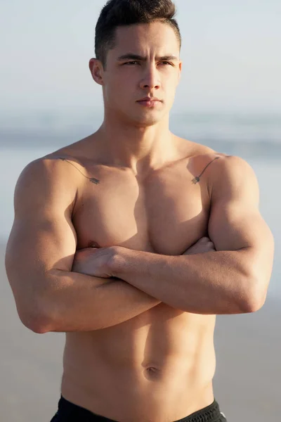 在海滩上做一些严肃的思考 一个英俊的年轻人站在海滩上抱着胳膊站着 — 图库照片
