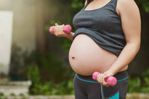 訓練中の母親 妊娠中の女性が外で運動していて — ストック写真