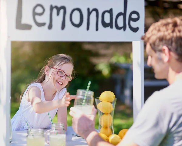 stock image Its a fun way for kids to learn about entrepreneurship. a little girl selling lemonade from her stand outside